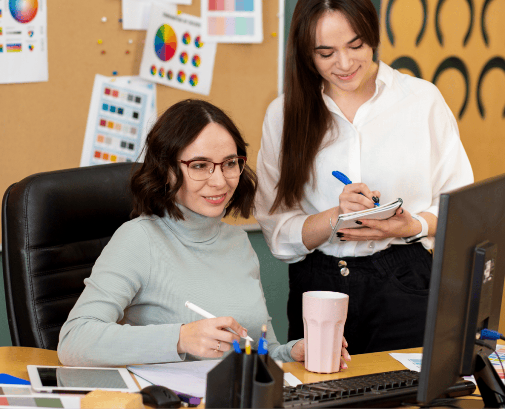Funnel & Web Experience Engineering 2 Two women collaborating on digital business strategies at a desk.