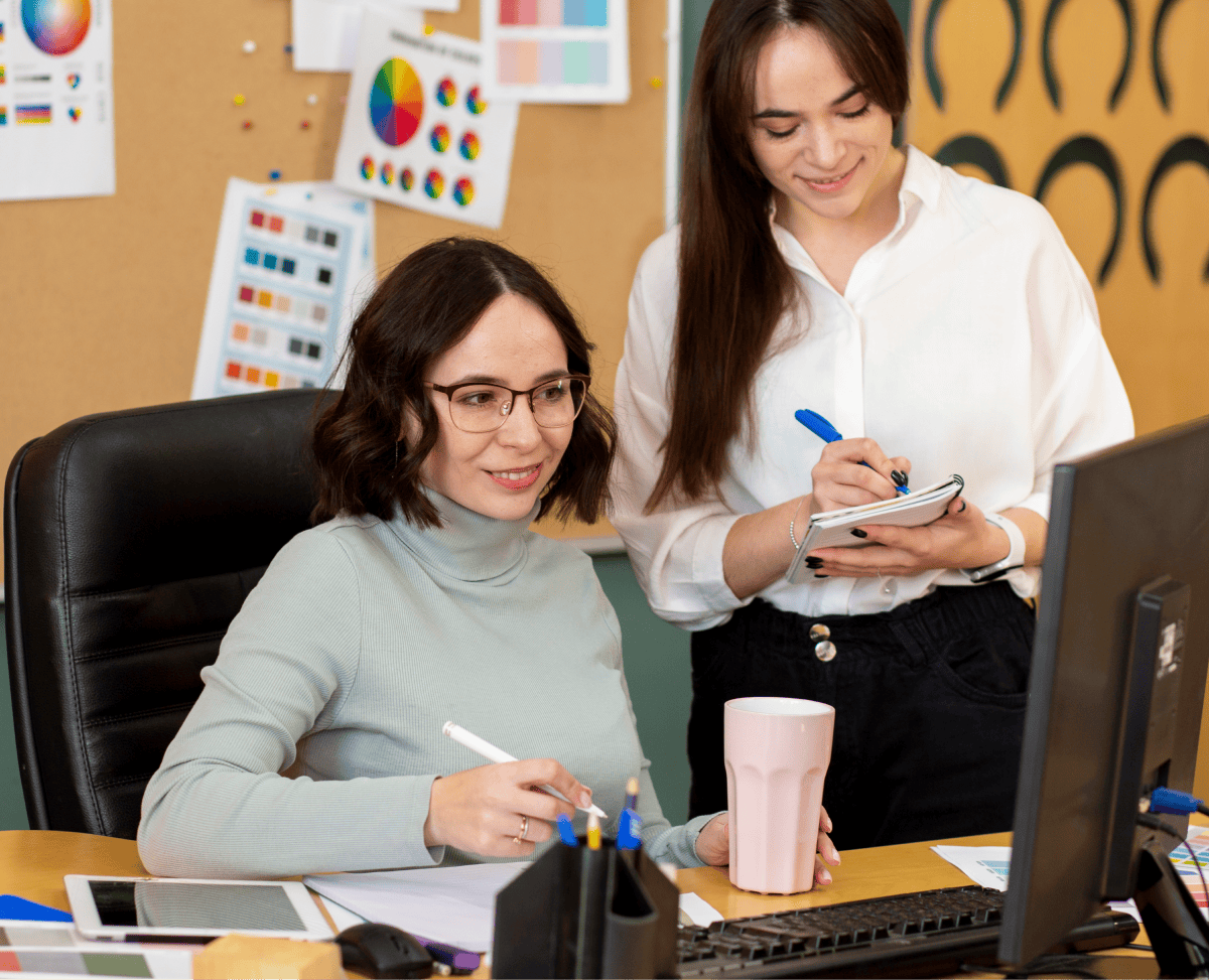 Two women collaborating on digital business strategies at a desk.