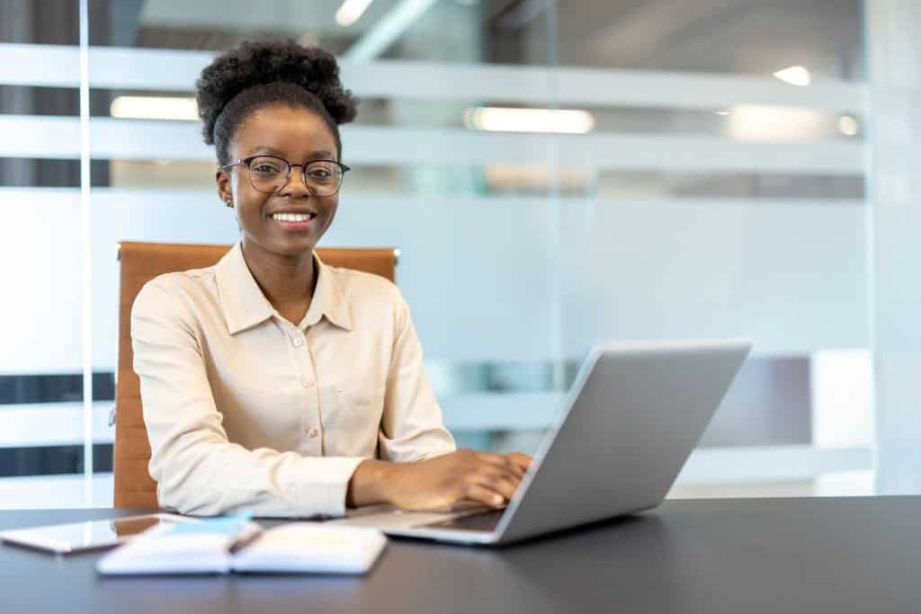 Professional woman working on a laptop in a modern office setting.
